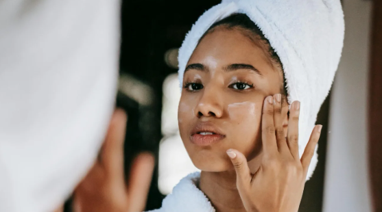 Image showing a woman putting face cream on her face, used in a personalized recommendation quiz that helps you find the right products for your needs.