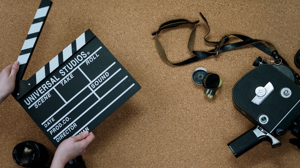 Image of a camera and a movie clapperboard, used in a movie selector quiz.