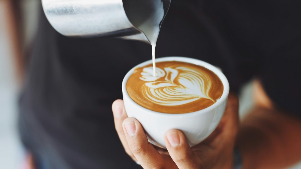 Image of a person pouring milk into a cup of coffee, used in a live quiz template.