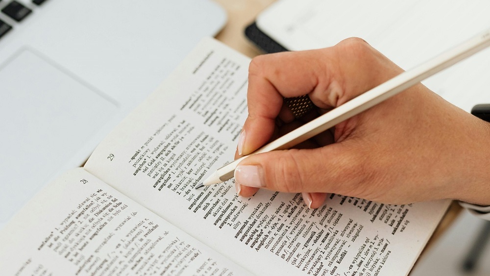 Image of a student studying the dictionary.